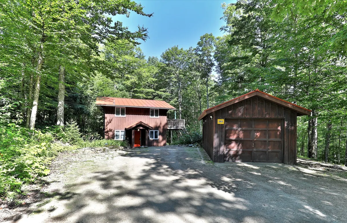 A welcoming exterior view of the two-story house surrounded by mature trees. The house’s inviting facade and garage suggest ample space and easy access for families returning from the slopes.